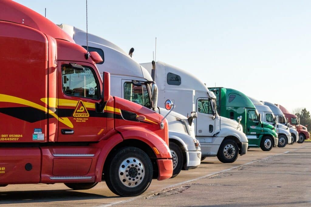 Semi-Truck Cabs lined up in a row in parking lot.