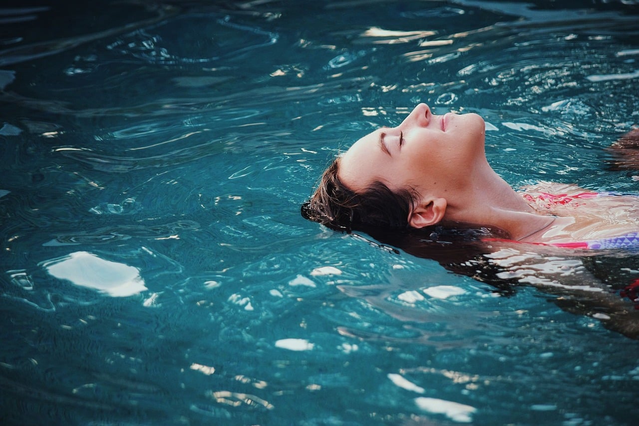 Woman swimming on back in pool