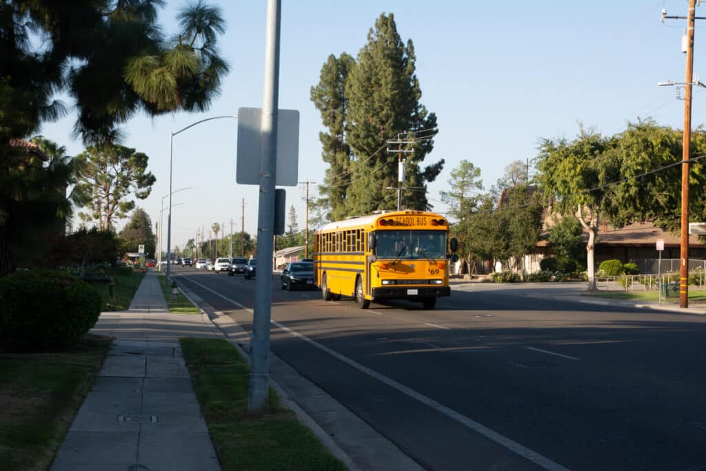Fresno School Bus leading line of traffic along Barstow Avenue.