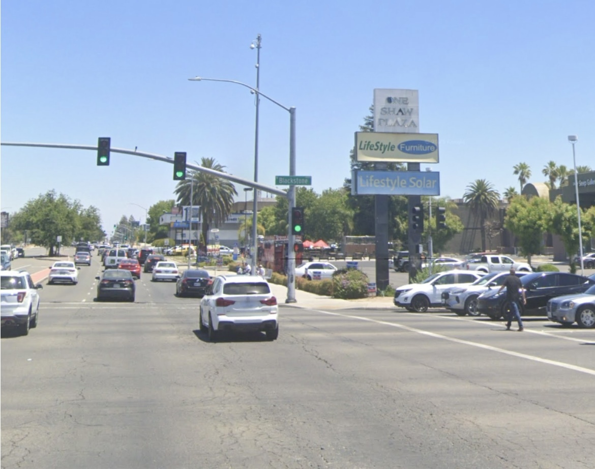 Man in black shirt crossing busy intersection at Blackstone Avenue and Shaw Avenue.