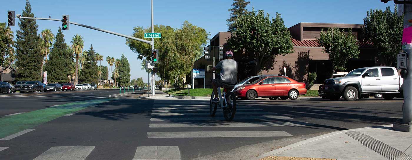 Bicyclist crossing a Fresno, CA street intersection