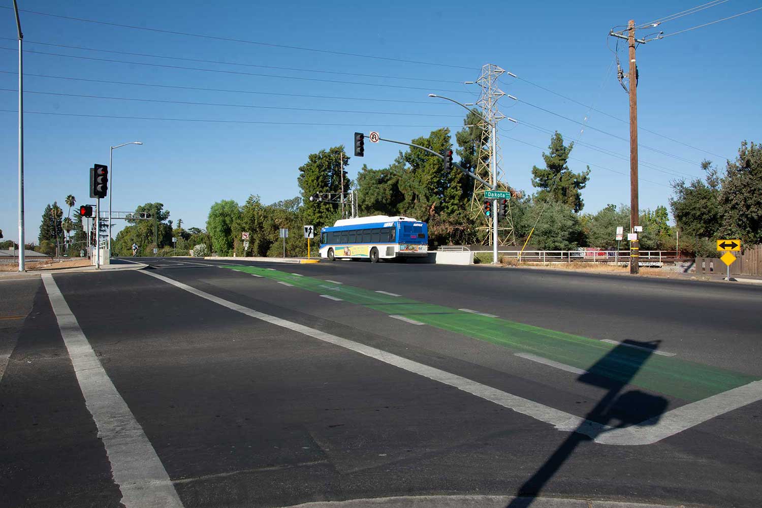 A green bike lane through the intersection of Dakota Avenue and Palm Avenue in Fresno.