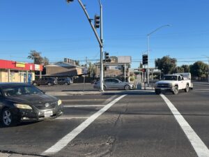 Vehicles entering the crosswalk at the intersection of First Street and Olive Street.