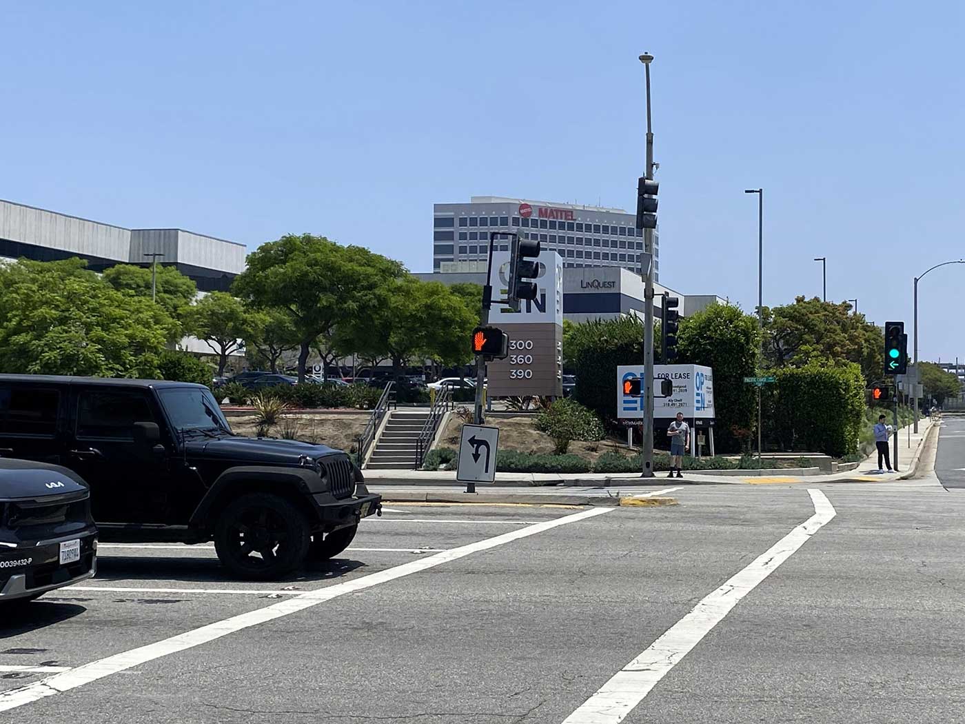 Pedestrians waiting at the crosswalk at Grand Avenue and Highway 1.